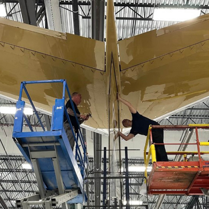 mechanics working on tail of private jet