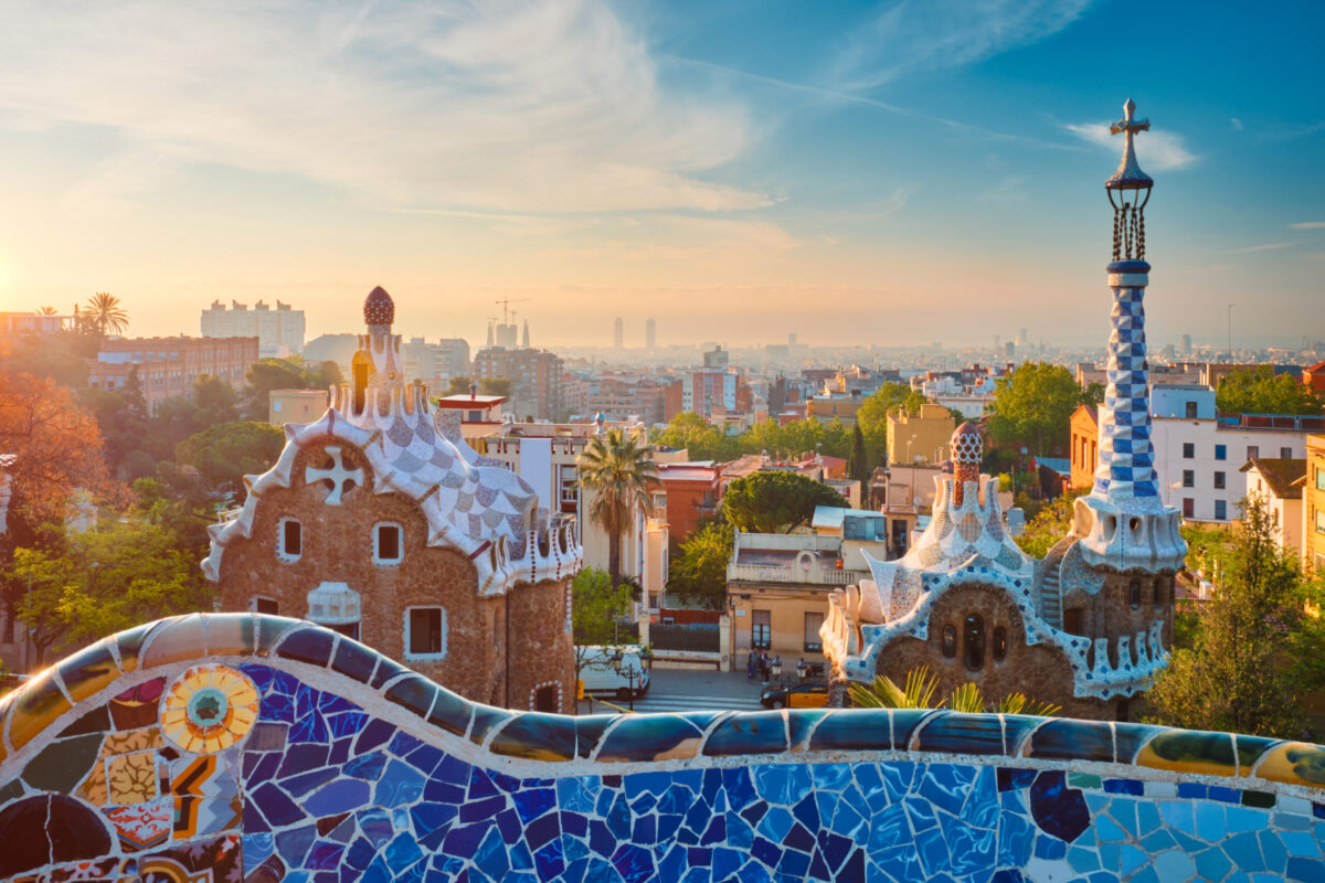 Barcelona city view from Guell Park with colorful mosaic buildings in tourist attraction Park Guell in the morning on sunrise. Barcelona, Spain