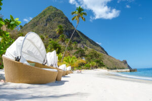 Sugar beach Saint Lucia, is a public white tropical beach with palm trees and luxury beach chairs on the beach of the Island St Lucia Caribbean.
