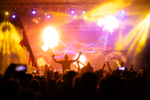 Crowd at concert - Cheering crowd in front of bright colorful stage lights