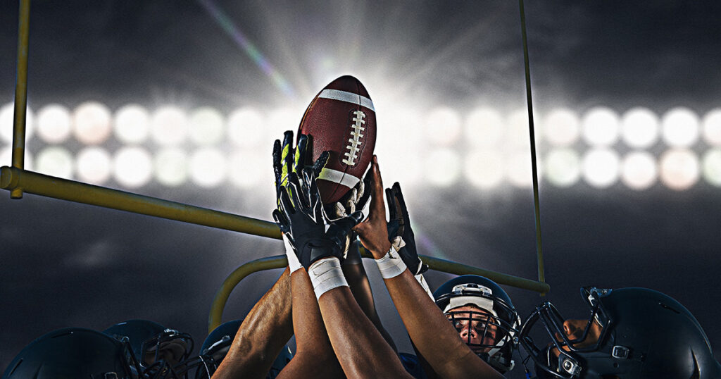 Victorious american football team holding up ball at the big game