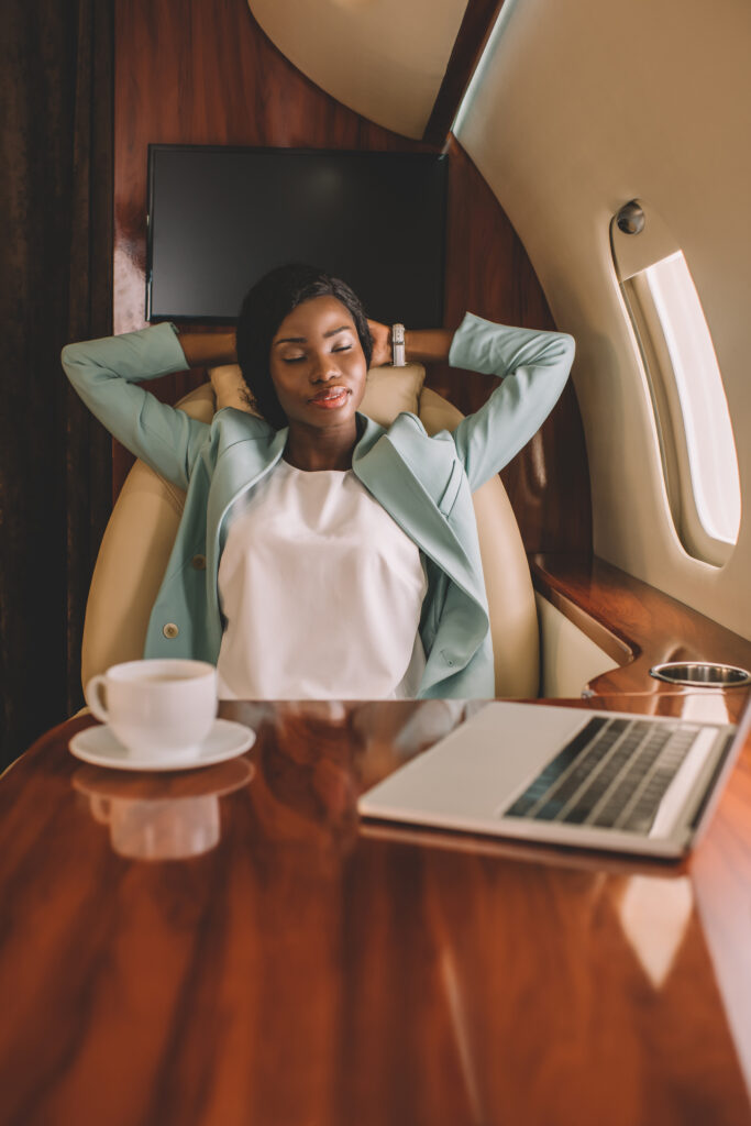 Business Travel | selective focus of african american businesswoman resting with closed eyes and hands behind head