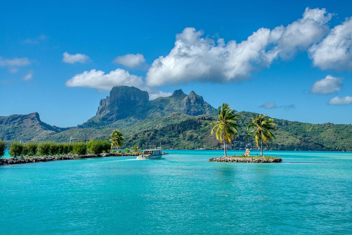 Bora Bora island on a sunny day with boats on the water